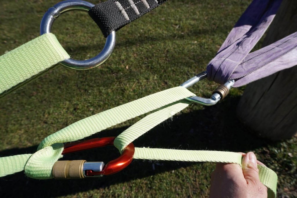Wir fädeln die Slackline durch den roten Karabiner